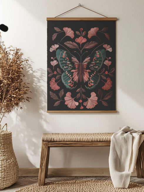 Hanging tapestry featuring a teal and pink butterfly surrounded by ginkgo-like leaves on a black background. The textile is suspended from wooden dowels with twine, creating detailed 3D embroidery-like texture.
